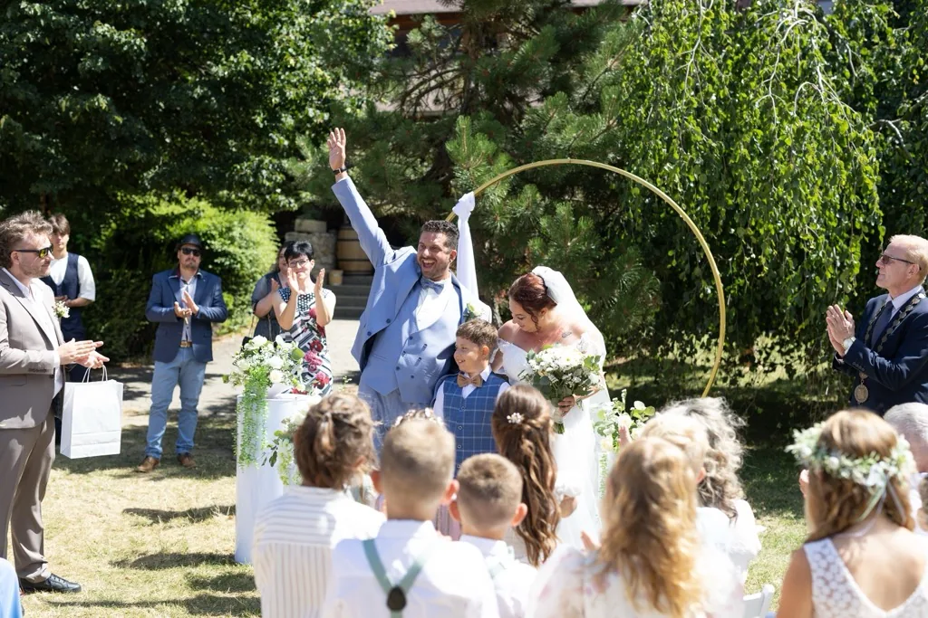 Novomanželé s hosty po svatebním obřadu v zeleni Na Kamínce