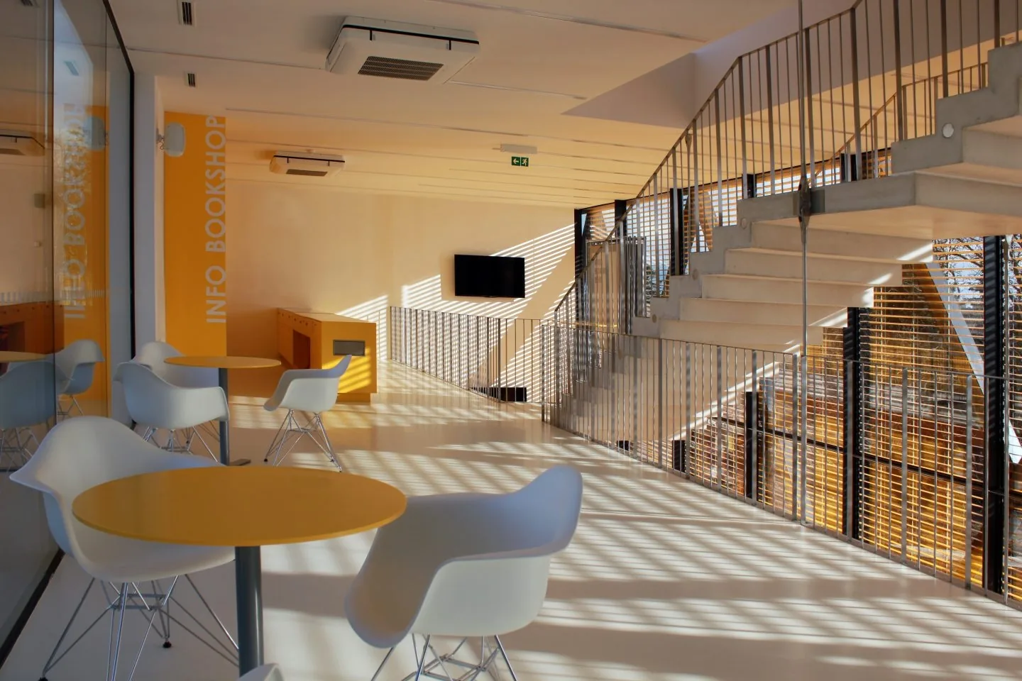 Posezení s malými stolky a křesly ve světlém foyer pavilonu Stiassny